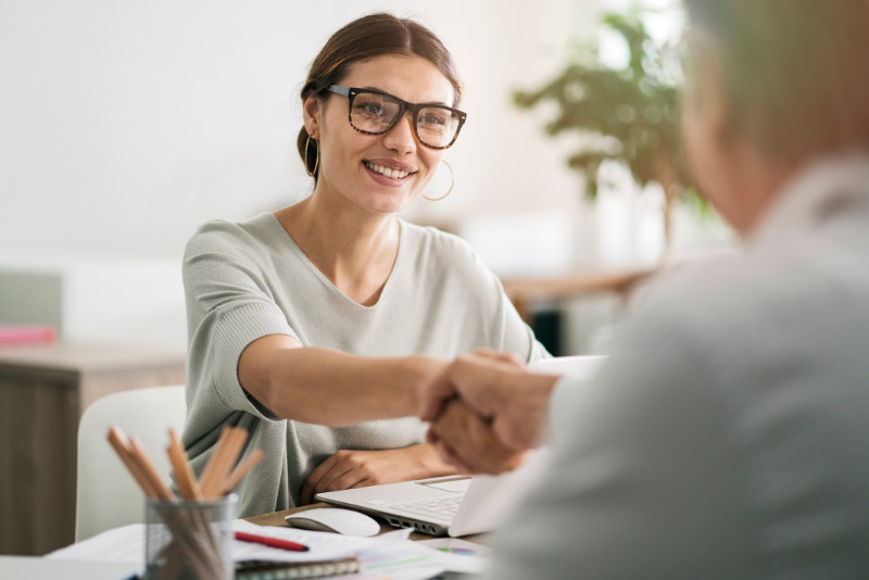 A real estate agent and a client shaking hands