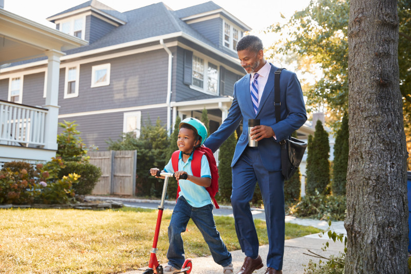 A businessman walking his son to school